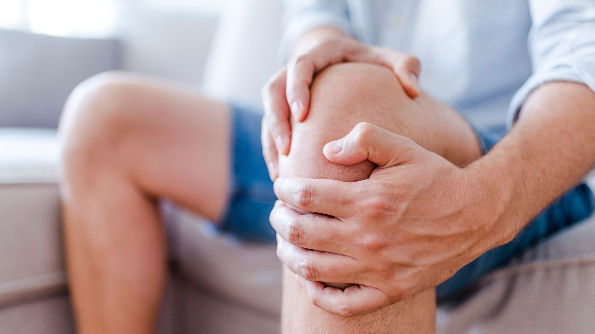 Man holding knee in pain